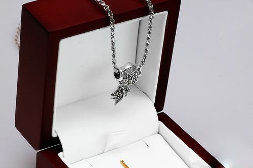 srebrny wisiorek przekładany z piórkiem i markazytami na Arena.pl