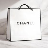 Biała torba prezentowa z napisem Chanel, z czarnym logo oraz premium