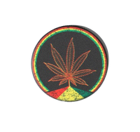 Młynek do Suszu z Pomarańczowym Liściem Marihuany Otoczony Kolorami Reggae