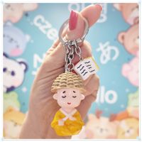 Breloczek brelok mądry Azjata z książeczką lekko uszkodzony