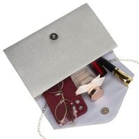 brokatowa kopertówka damska w srebrnym kolorze zawieszona na eleganckim